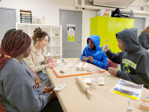 Catholic Charities participating in the clay mandala workshop in the Education Center. 
