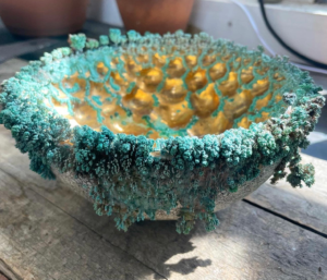 A coral bowl, made of ceramic and metallic crystals